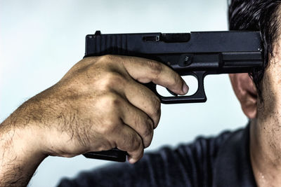 Close-up of man shooting him with handgun