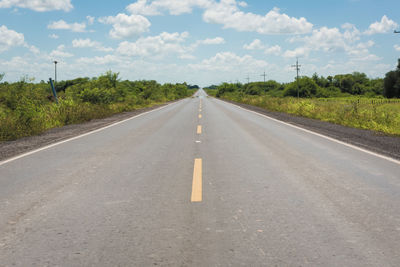 View of road amidst trees against sky