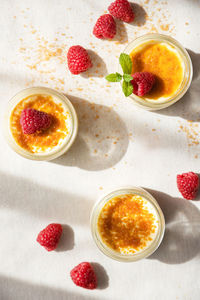 Top view of creme brulee dessert with baked sugar and fresh berries in bright sunshine 