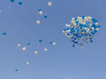 Low angle view of balloons against blue sky