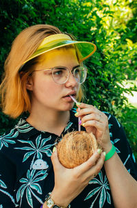 Young woman drinking coconut water with straw