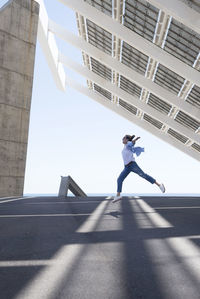 Low angle view of woman against sky on sunny day