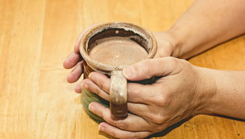 Hands holding coffee cup