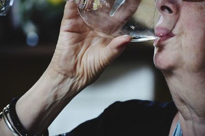 Cropped image of woman drinking alcohol