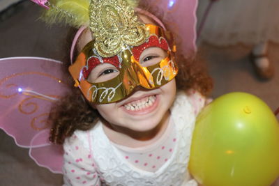 Close-up portrait of smiling girl with mask