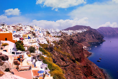 High angle view of townscape by sea against sky