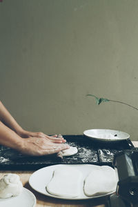 Cropped hand of man preparing food on table