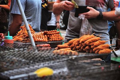 Midsection of man buying food at market