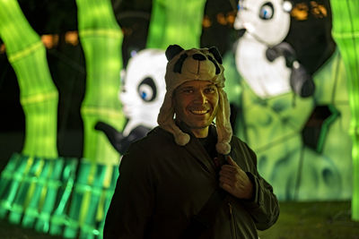 Portrait of smiling man wearing panda cap at amusement park