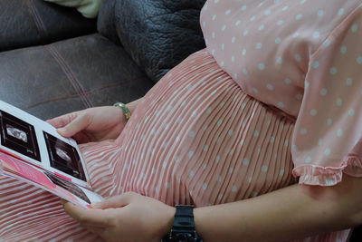 Low section of woman relaxing on bed