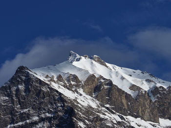 Low angle view of snowcapped mountains against sky