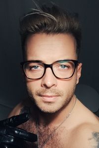 Close-up portrait of young man against black background