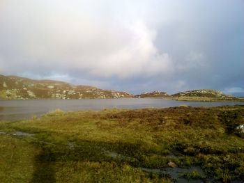 Scenic view of mountains against cloudy sky