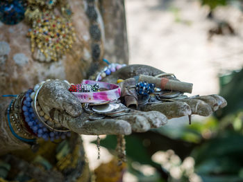 Close-up of donations to buddhist temple in hands of buddha statue, chiang mai, thailand