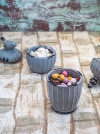 Easter sweets, chocolate eggs and dried fruits in gray ceramic dishes