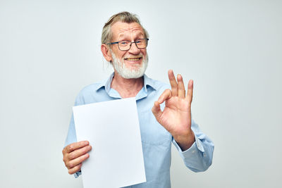 Portrait of man holding document while gesturing