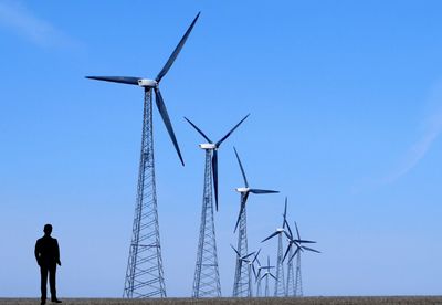 Low angle view of windmill against clear blue sky