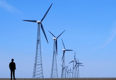 Low angle view of windmill against clear blue sky