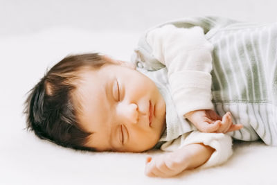 Portrait of cute baby sleeping on bed