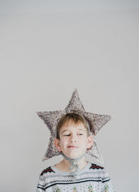 Boy wearing star shape decoration against white background