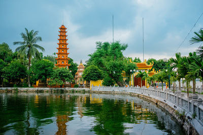 Panoramic view of building by lake against sky