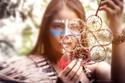 Close-up portrait of woman holding leaf