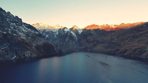 Scenic view of lake and mountains against clear sky