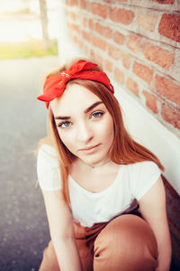 Portrait of beautiful young woman sitting outdoors