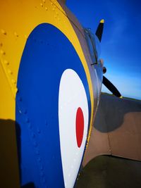 Low angle view of arrow sign against blue sky
