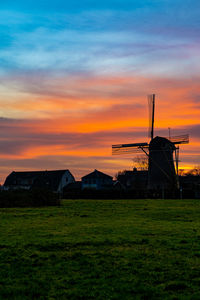 Built structure on field against sky during sunset