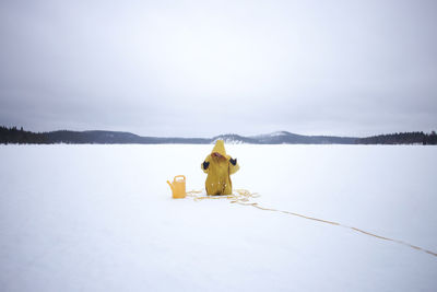 Woman wearing yellow hood stuck in snow