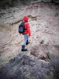 Rear view of man walking on rock