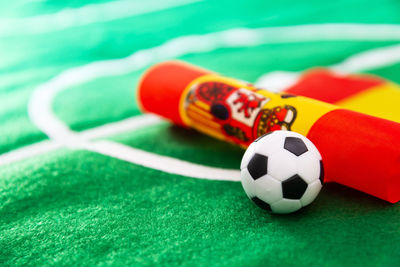 Close-up of small soccer ball with flag on green textile