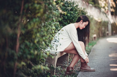 Woman tying shoelaces outdoors