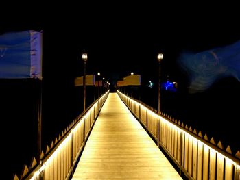 Illuminated bridge against sky at night