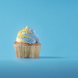 Low angle view of cupcakes against blue background
