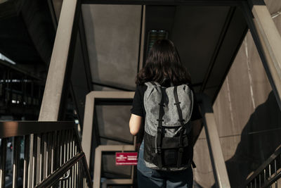 Rear view of woman standing on staircase