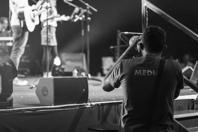 Rear view of man standing at music concert