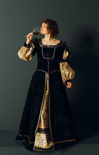 Young woman standing against black background