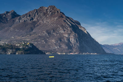 Scenic view of sea by mountains against sky