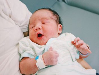 Portrait of cute baby boy sleeping on bed at home