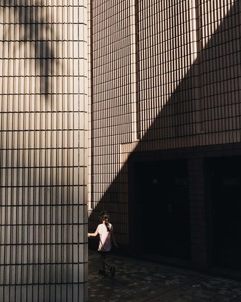 WOMAN STANDING BY BUILDING