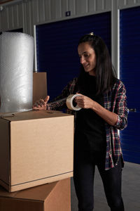 Young woman smiling while holding camera in box
