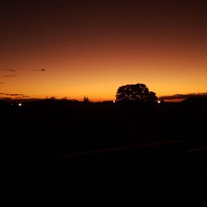 Silhouette landscape against clear sky at sunset