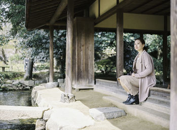 Full length of woman sitting on bench