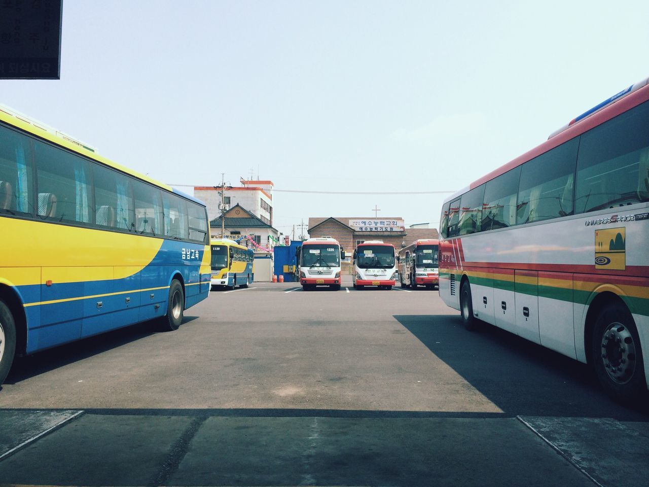 transportation, architecture, built structure, mode of transport, building exterior, land vehicle, car, street, road, city, road marking, clear sky, travel, the way forward, sky, incidental people, public transportation, day, outdoors, building