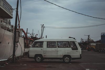 Cars on street in city against sky