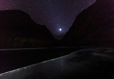 Scenic view of lake against mountain at night