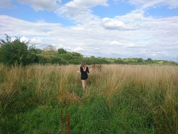 Rear view of woman walking on grassy field