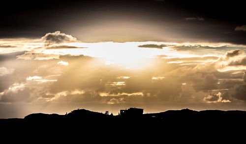 Low angle view of silhouette mountain against dramatic sky